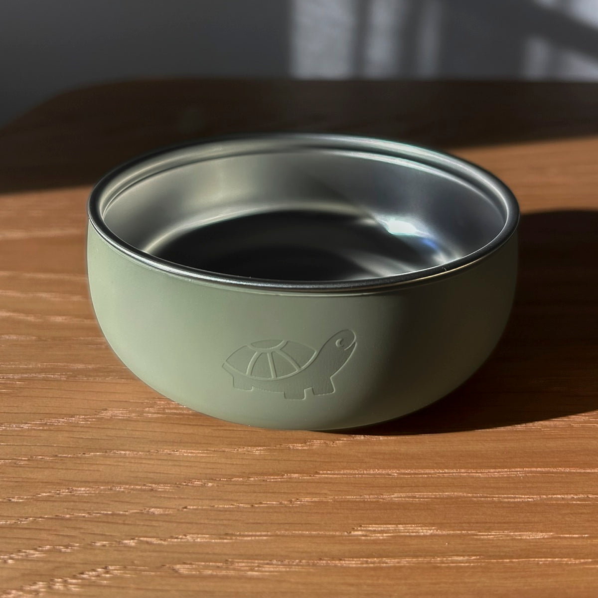 Sage NoToxTots bowl, front view, on a wooden table