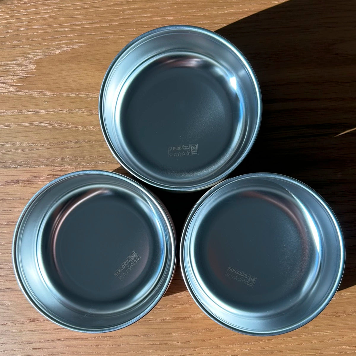 Three NoToxTots bowls from above, showing the bare stainless-steel inside